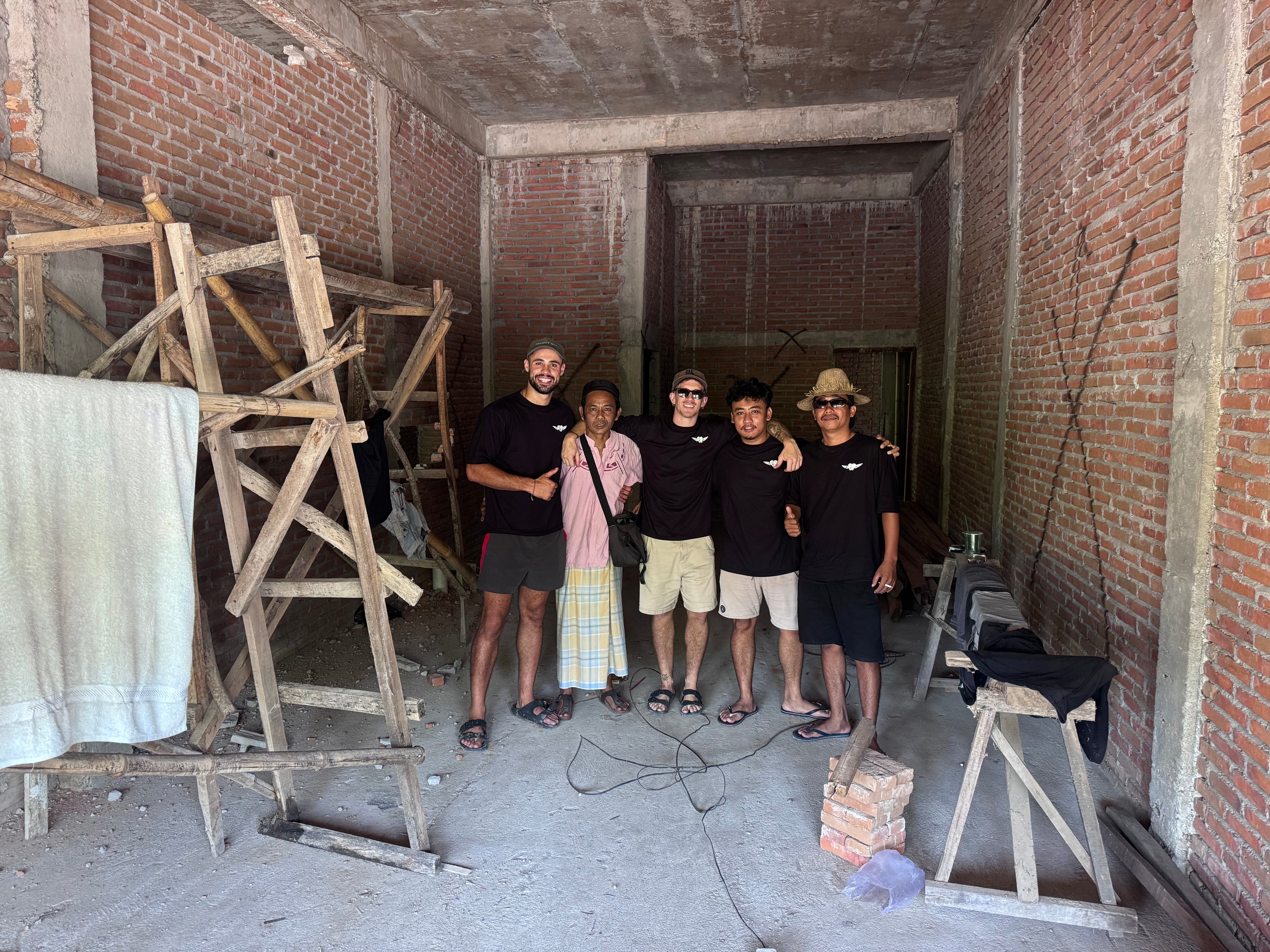 Cargar video: Video of The Little Warrior Project organisers signing papers, hugging, and celebrating on the construction site in Lombok, Indonesia. The team smiles and embraces as the project officially begins, symbolising hope and community.